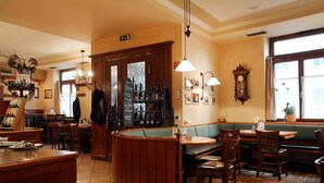 A cozy restaurant with wooden furniture, a bar area, and a seating arrangement.