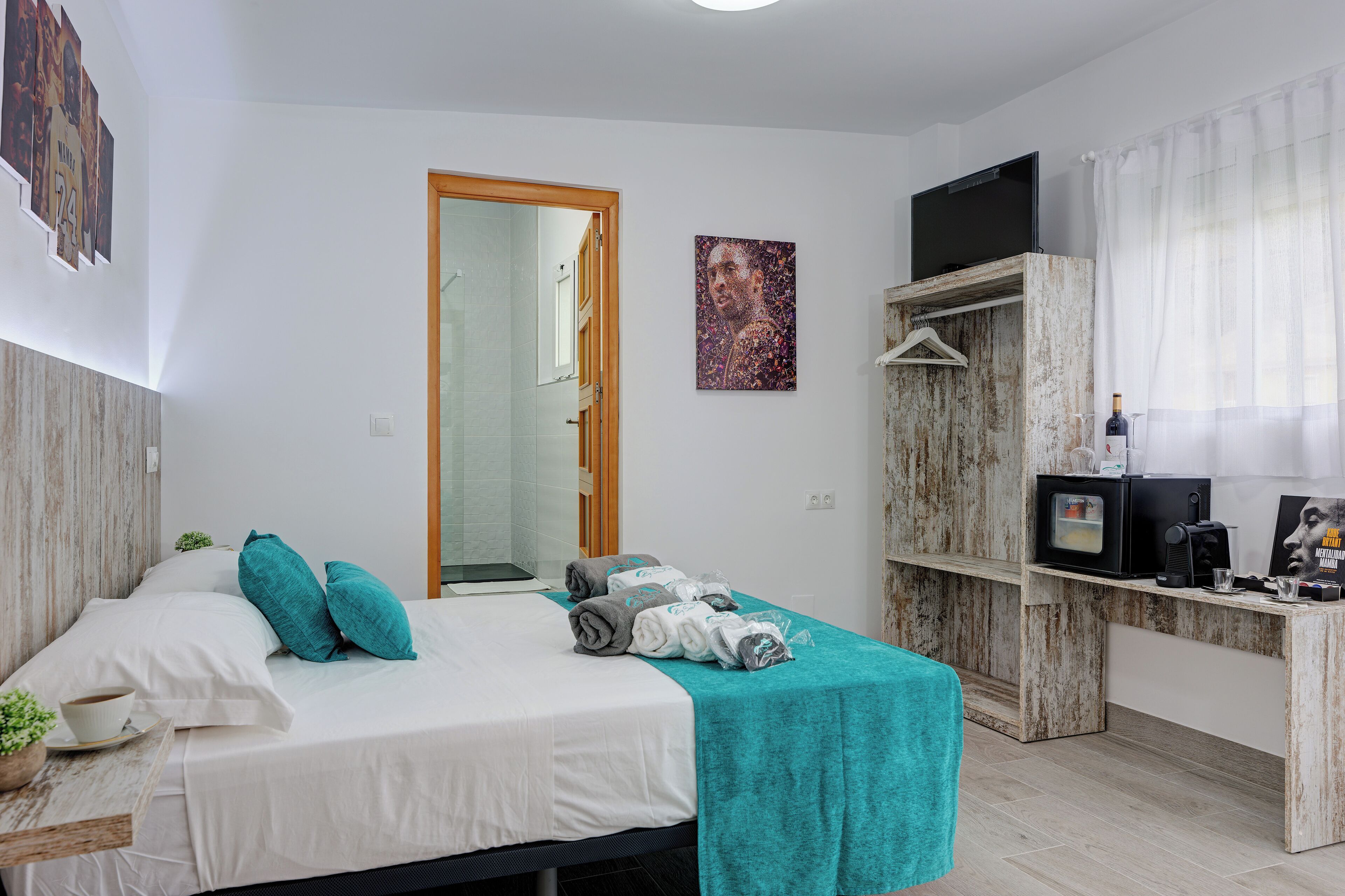 Une chambre à coucher moderne avec un lit, un bureau et un téléviseur.