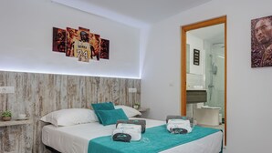 Ein modernes Schlafzimmer mit einem Bett, einem Türkis-Wurfdecken und Bildern an der Wand.