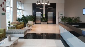 A modern lobby with a reception desk, seating area, and elevators. - Mia Hotel Chocó By OxoHotel (Quibdó)