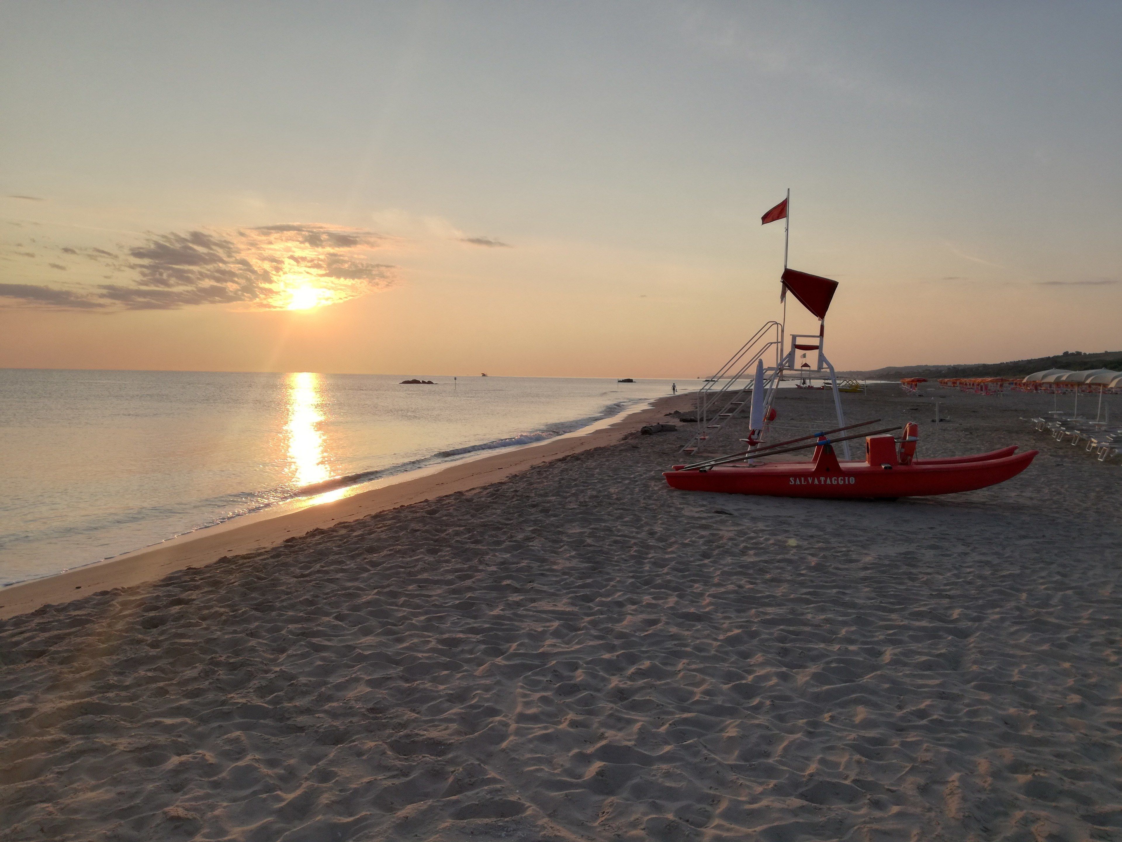 Ein Strand mit einem Rettungsboot und einem Rettungsturm.