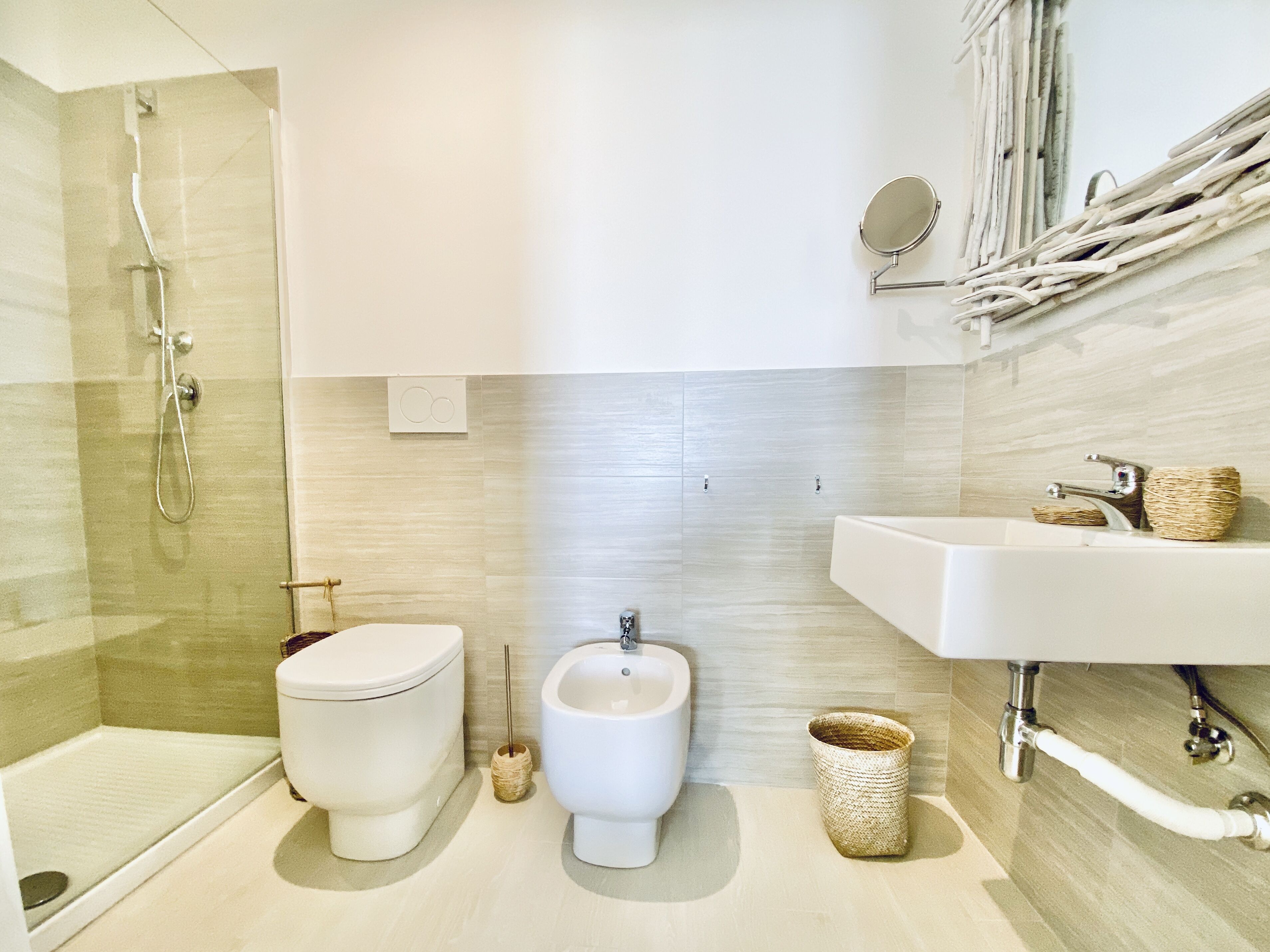 A modern bathroom with a toilet, bidet, and shower.