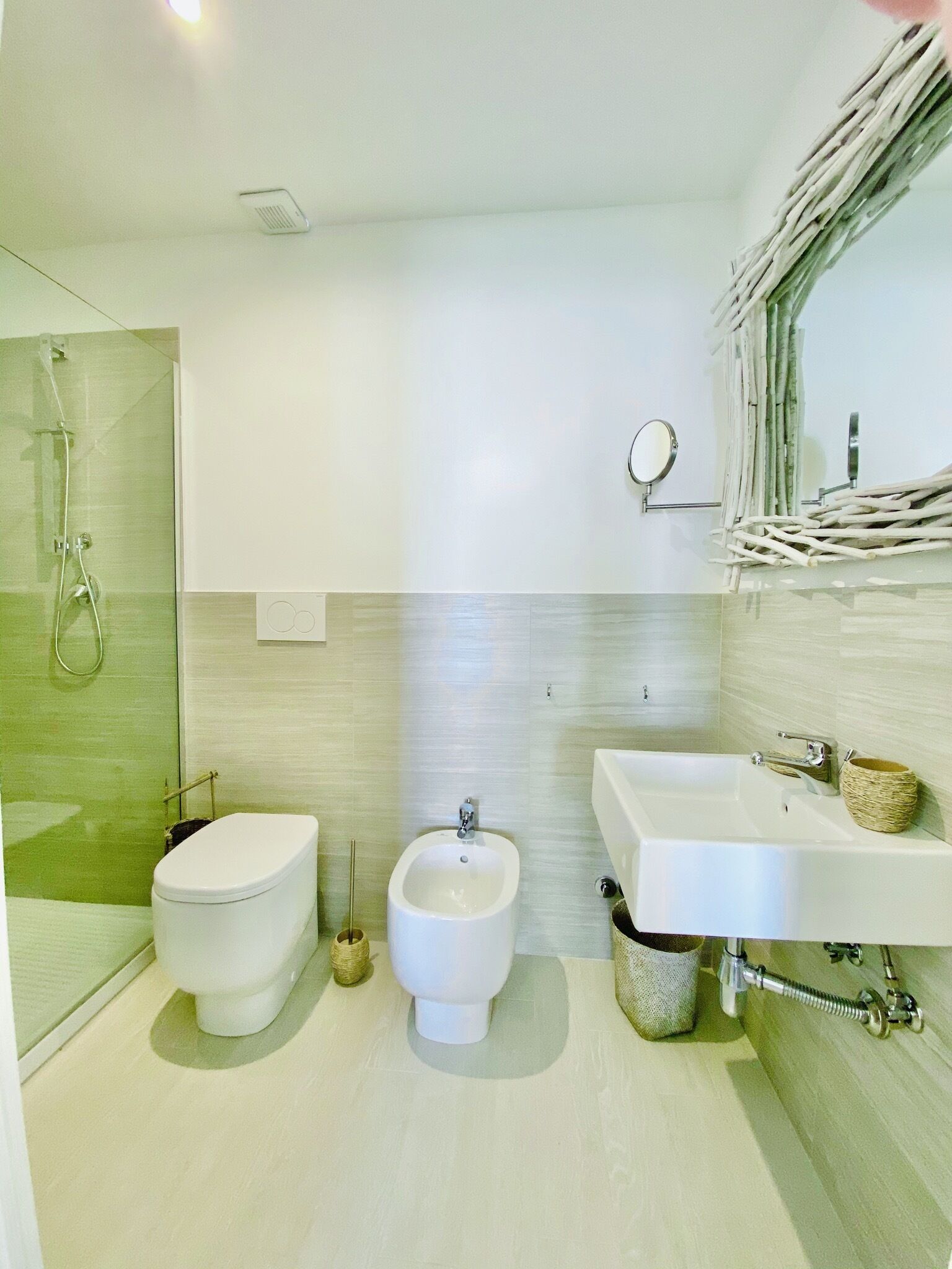 Une salle de bain moderne équipée de toilettes, d’un bidet et d’un espace douche.