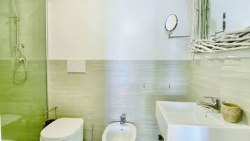 Une salle de bain moderne équipée de toilettes, d’un bidet et d’un espace douche.