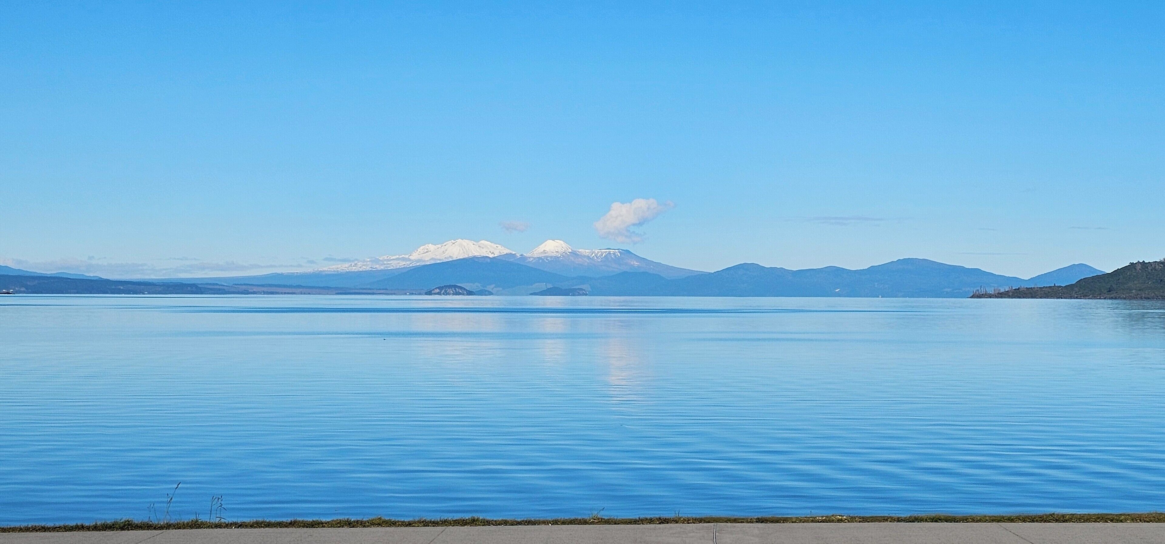 A calm lake with mountains in the background.
