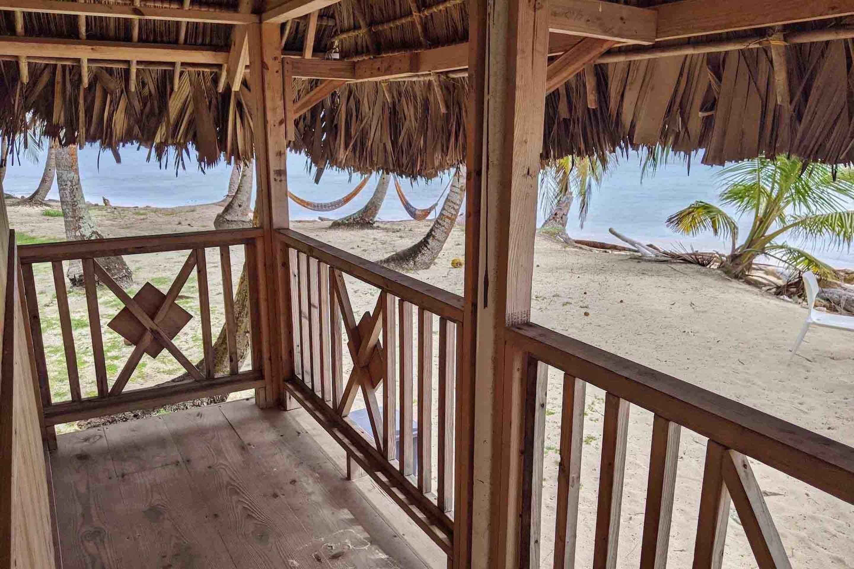 A wooden structure with a thatched roof overlooking a beach.