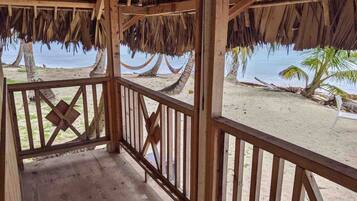 A wooden structure with a thatched roof overlooking a beach.