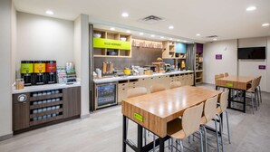 A modern kitchen area with a coffee station, a breakfast bar, and a dining area with tables and chairs. - Home2 Suites by Hilton Houston IAH Airport Beltway 8 (Houston)