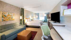 A hotel room with a sofa, a desk, a television, and two beds. - Home2 Suites by Hilton Houston IAH Airport Beltway 8 (Houston)