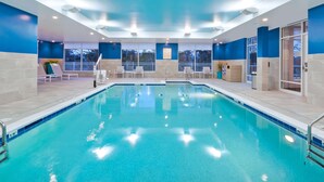 An indoor swimming pool with clear blue water, surrounded by white lounge chairs and a tiled floor. - Hampton Inn Cape Cod Canal (Buzzards Bay)