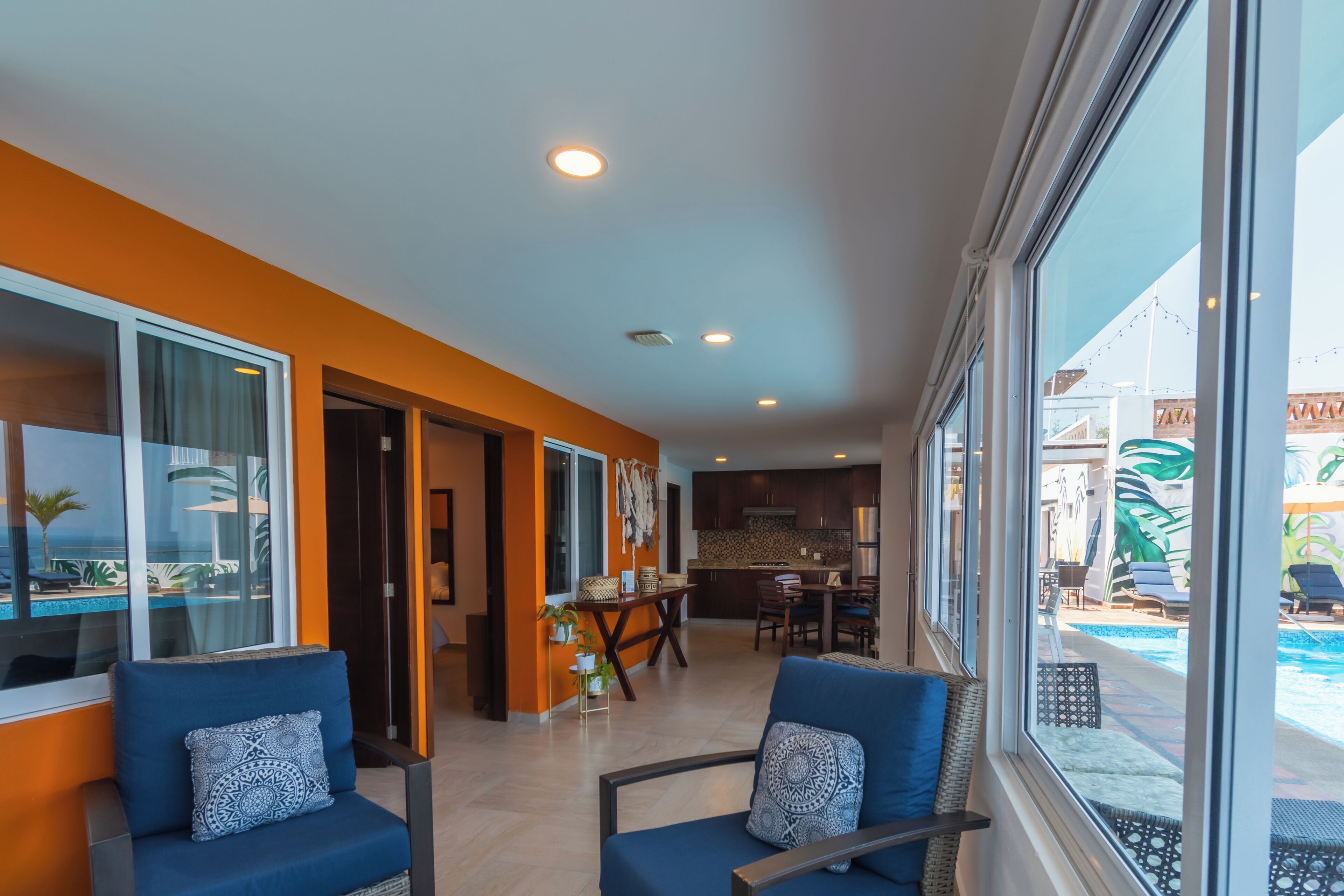 Una habitación de hotel moderna con un ventanal grande, un comedor y una cocina.