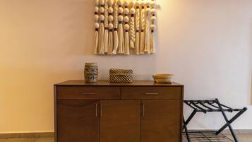 A wooden cabinet with three drawers and a hanging rack.