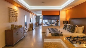 A modern hotel room with a large bed, a kitchen area, and a dining area. - The Paramar Beachfront Boutique Hotel - Downtown Malecon (Puerto Vallarta)