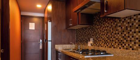 Une cuisine moderne avec des meubles en bois, un plan de travail en granit et une cuisinière intégrée.
