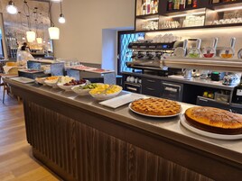 Un banco buffet con diversi cibi e una macchina per il caffè.