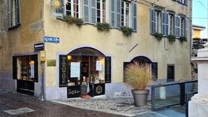 A building with a sign for "Hotel Ristorante Sole" and a potted plant in front. - Il Sole Bergamo (Bergamo)