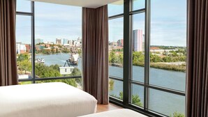 A hotel room with large windows offering a view of a river and cityscape. - Homewood Suites by Hilton Wilmington Downtown (Wilmington)