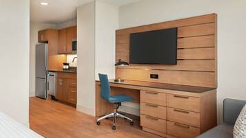 A modern kitchen with wooden cabinets, a built-in microwave, and a stainless steel refrigerator.