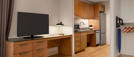 A modern kitchen with wooden cabinets, a built-in oven, and a refrigerator.