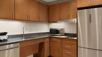 A modern kitchen with wooden cabinets, stainless steel appliances, and a patterned backsplash.