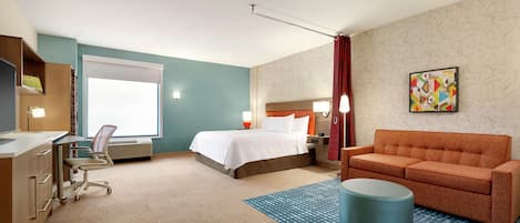 A hotel room with a bed, a desk, a chair, a sofa, and a large window.