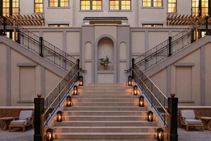 A grand staircase with multiple steps leading up to a central landing, flanked by two sets of railings.