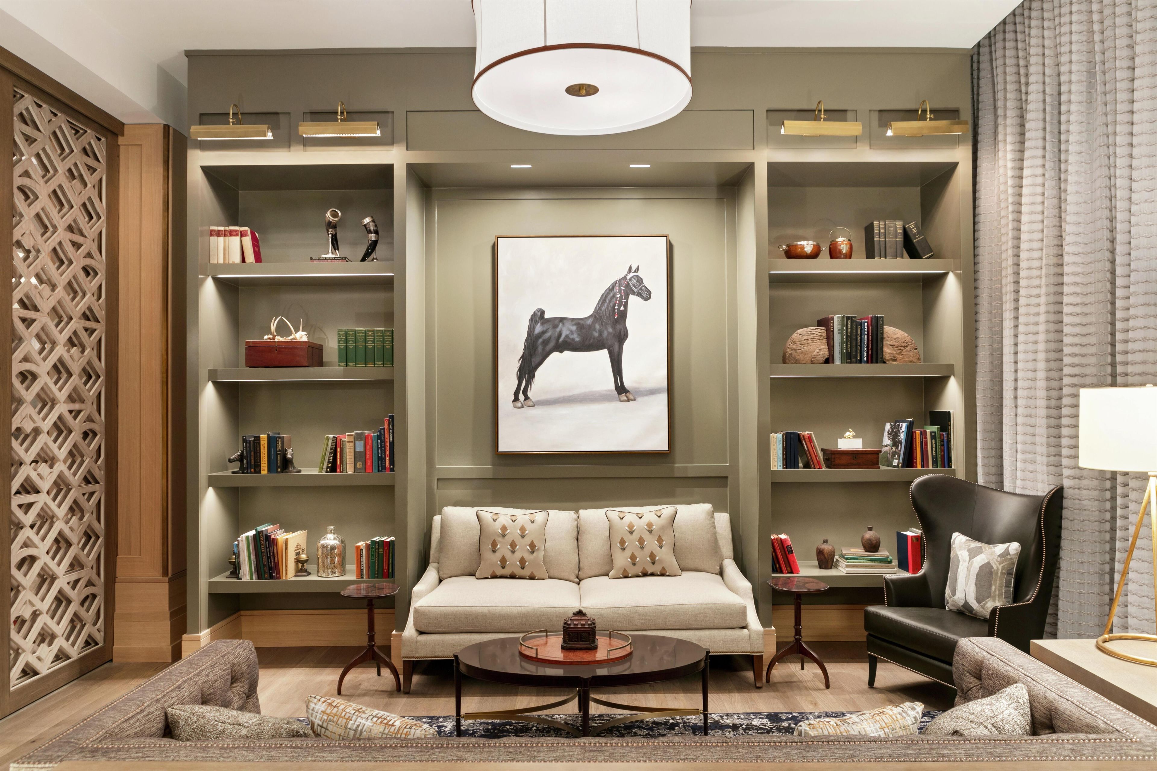 A modern living room with a sofa, coffee table, and bookshelves.