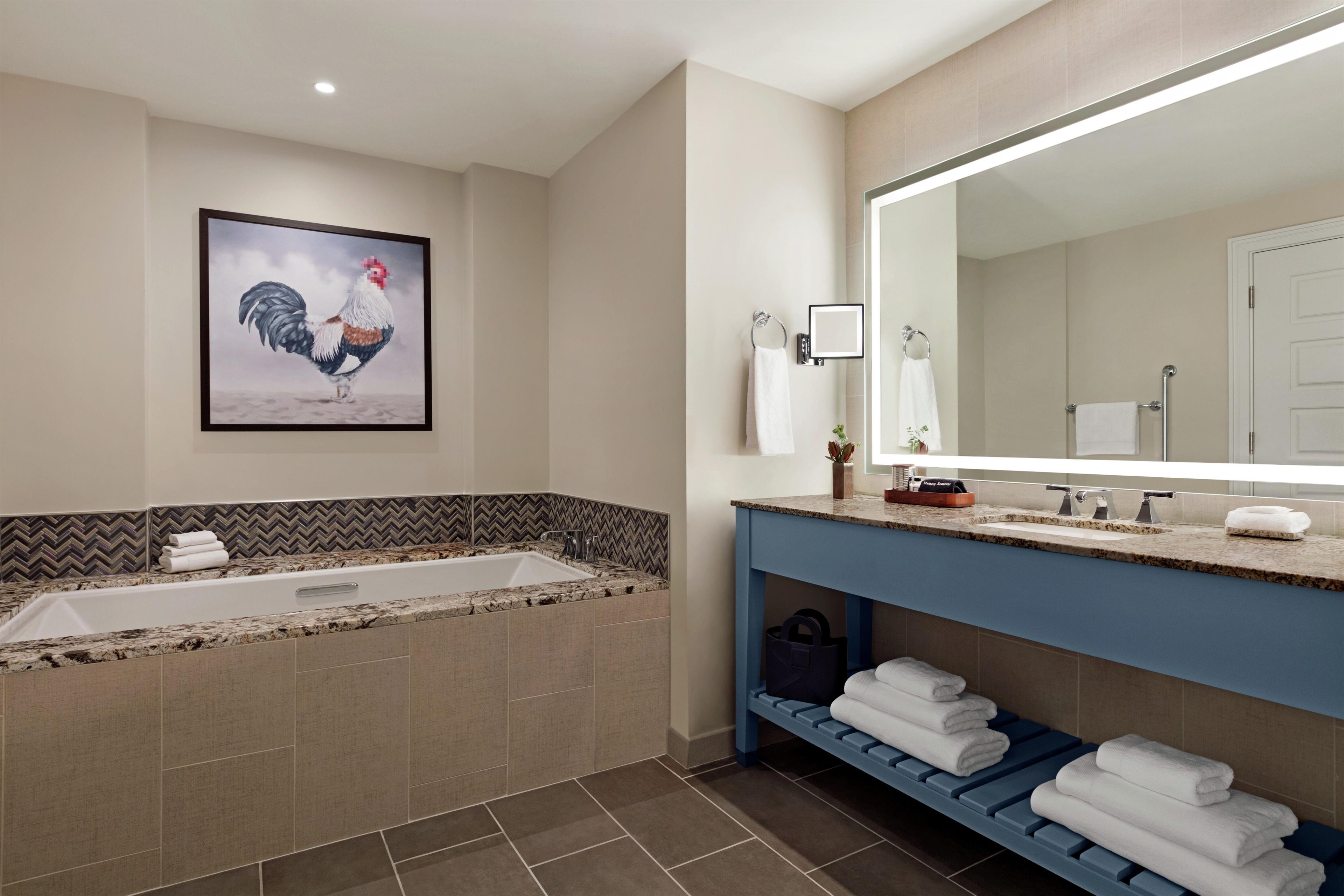 Un baño moderno con un espejo grande, una bañera y una ducha.