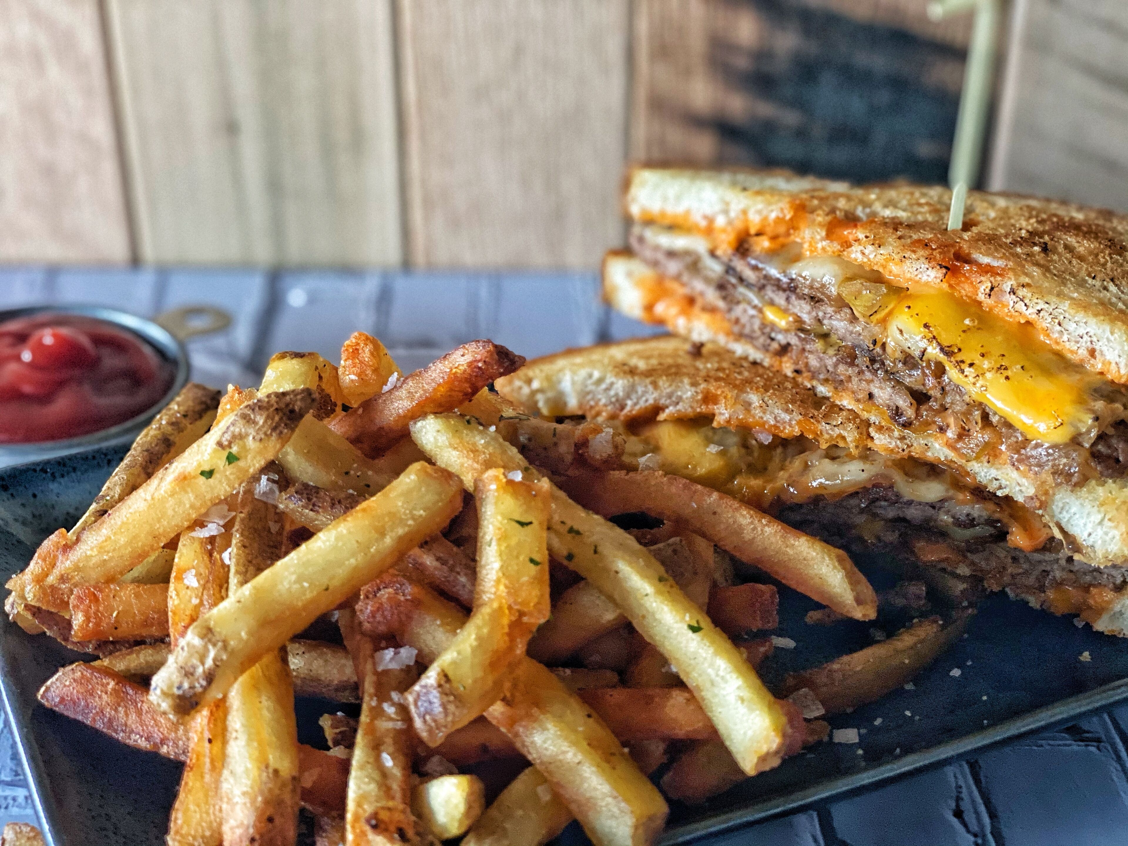 A plate with a grilled sandwich and French fries.