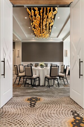 A conference room with a round table, chairs, and a decorative ceiling light fixture. - The Harpeth Franklin Downtown, Curio Collection by Hilton (Franklin)