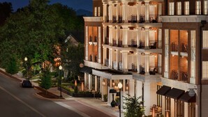 A multi-story hotel with a grand entrance, outdoor seating, and a well-lit facade. - The Harpeth Franklin Downtown, Curio Collection by Hilton (Franklin)
