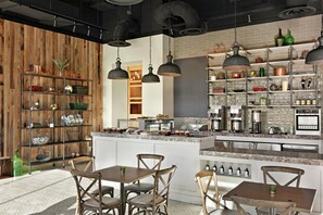 A modern kitchen with a central island, wooden shelving, and pendant lighting.