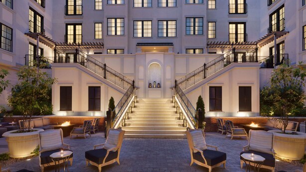 A hotel courtyard with outdoor seating, a central staircase, and a fire feature. - The Harpeth Franklin Downtown, Curio Collection by Hilton (Franklin)