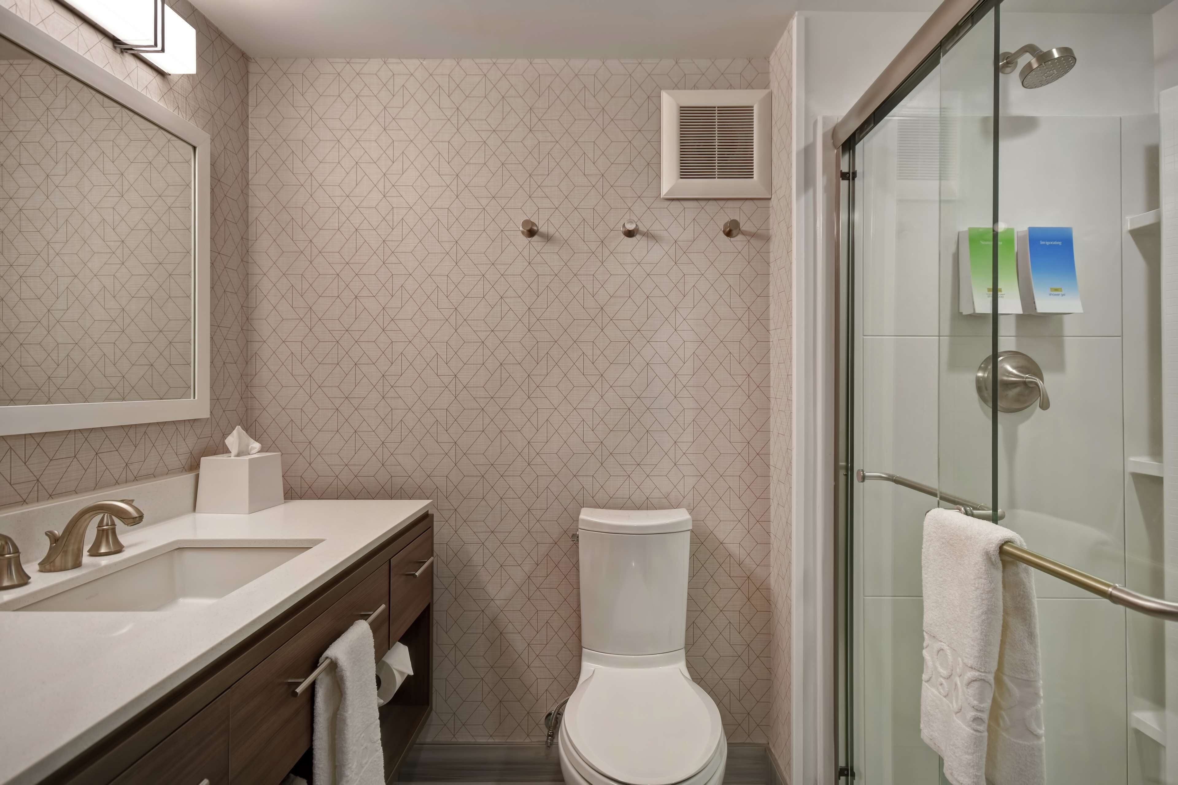 A bathroom with a toilet, sink, and shower area.