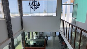 A spacious indoor area with a glass-bottomed aquarium, wooden cabinets, and a chandelier. - New House by The Beach (Pisco)