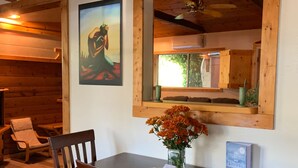 Ein Holztisch mit Stühlen, eine Blumenvase und ein Willkommensschild darüber.