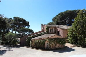 A traditional building with a sloped roof, surrounded by trees and a gravel driveway. - Villa sea view, quiet close to the center of Sainte Maxime. (Sainte-Maxime)