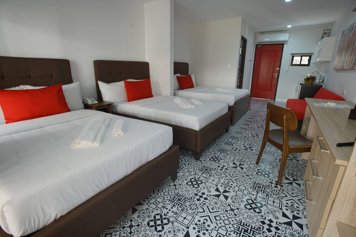 Habitación triple Deluxe, vista al jardín | Camas Tempur-Pedic, decoración personalizada y muebles diferentes