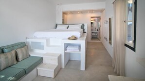Un dormitorio moderno con una cama, un sofá verde y un vestidor.
