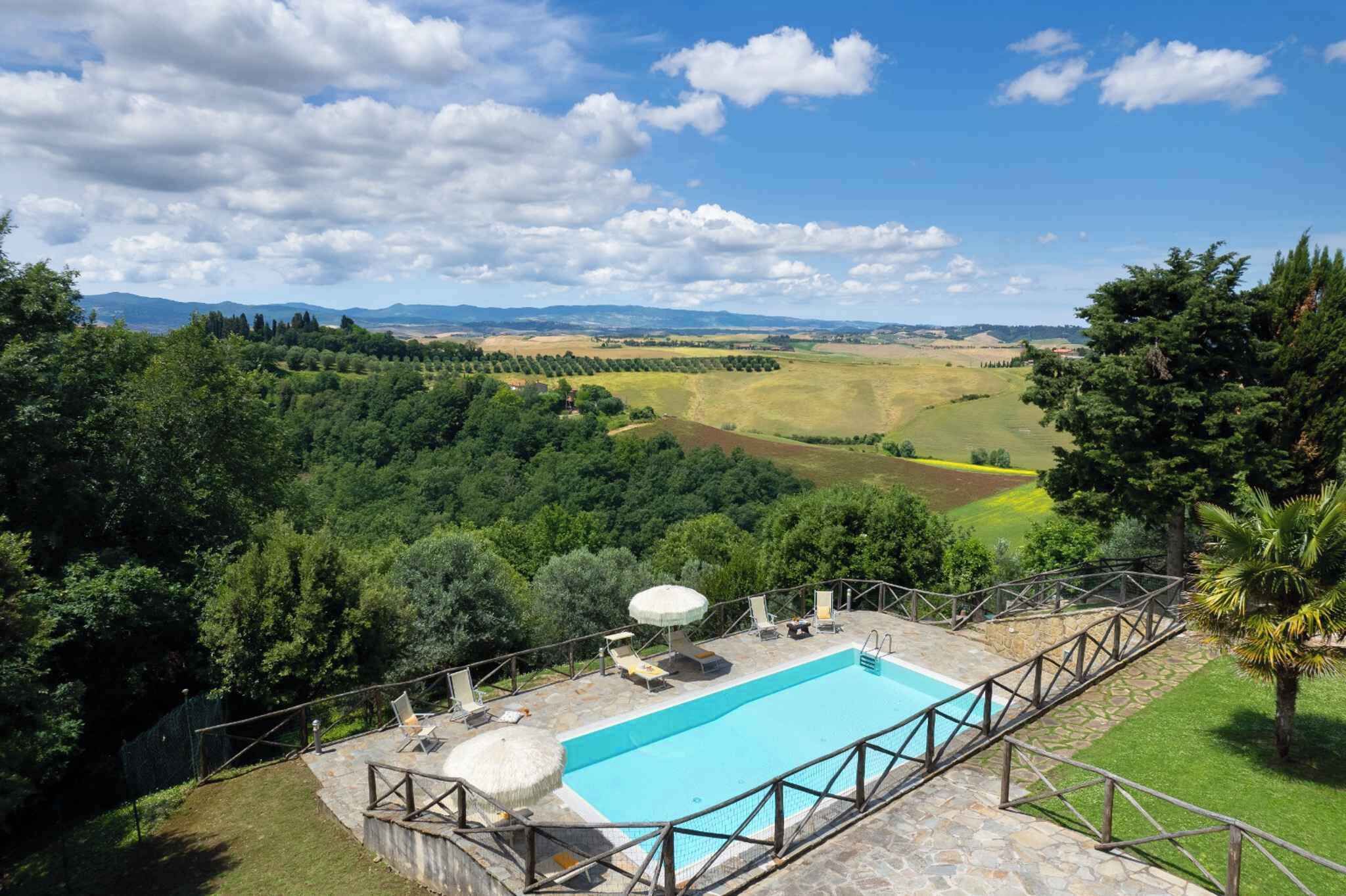 Una piscina con vistas a un paisaje exuberante, rodeada de árboles y una terraza de piedra.