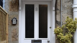 A white door with the number 8, a small window, and a potted plant beside it. - St Ives Cottage near beach. Sleeps 4, with Courtyard Garden + Log Burner (Saint Ives)