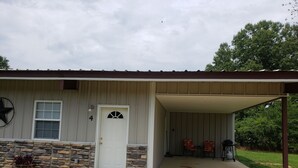 A single-story house with a stone foundation, a white door, and a covered garage.