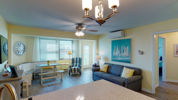 A living room with a dining area, a ceiling fan, a painting, and a clock on the wall. - Jo's Hideaway, for Lake Erie lovers, fishermen and birders!  Sleeps 4 (Oak Harbor)