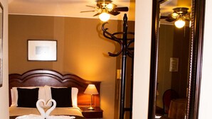 A hotel room with a bed, a nightstand, a lamp, a floor lamp, and a large mirror. - Hotel Solís Dies (Lima)