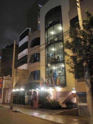 Um hotel com design moderno, apresentando várias varandas e grandes janelas.