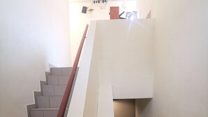 Una escalera con barandilla blanca y escalones color beige que conducen a una plataforma.