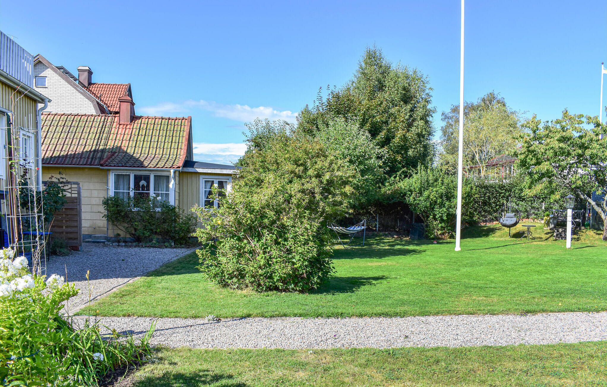A residential property with a well-maintained lawn, a hammock, and a tall flagpole.