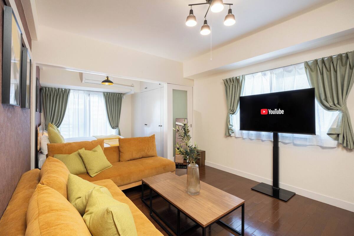 Una sala de estar moderna con un sofá, una mesa de centro y un televisor de pantalla plana.