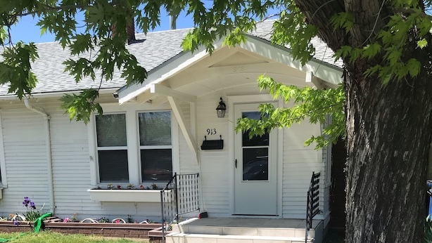 A two-story house with a front porch, a mailbox, and a number '913' on the door. - Best Location (Cody)