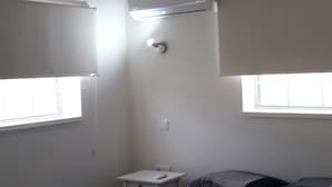 A bedroom with a bed, a ceiling fan, a small table, and a window. - Villa Buena, fantastic luxury villa with internet/ wifi (Hato)